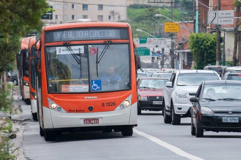 Bus (Mercedes-Benz O 500 MA) on front, passing in São Paulo city bus stop in Av. Corifeu De Azevedo Marques, 3637. Buses