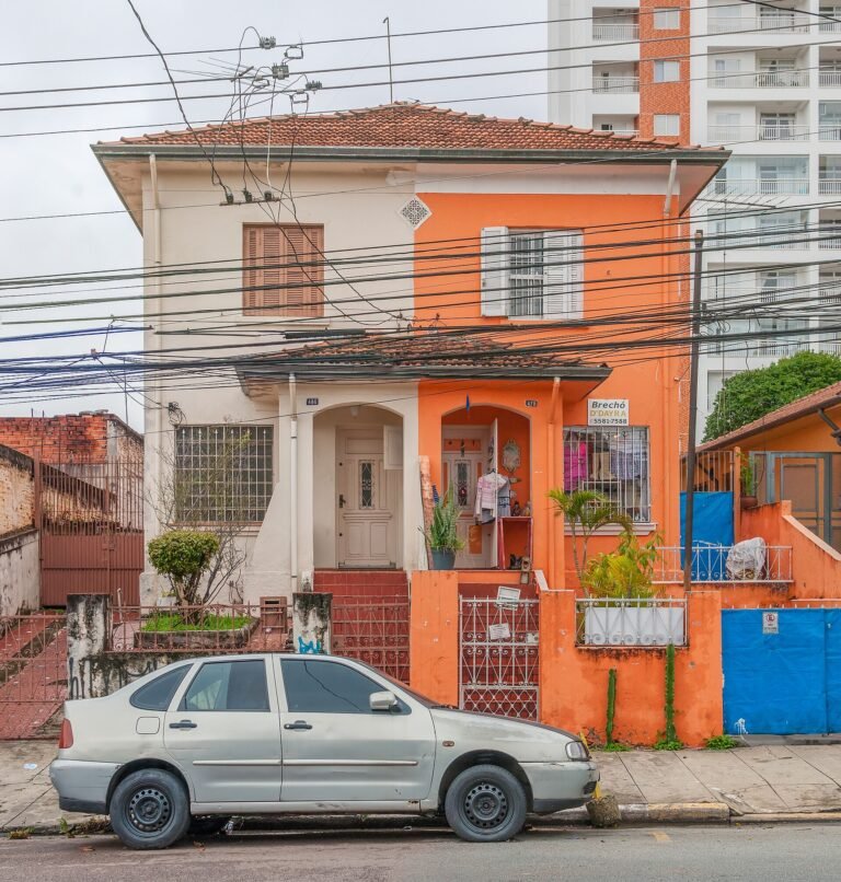 A house in the Saúde district, its front painted orange beside a white neighbour. São Paulo, Brazil.